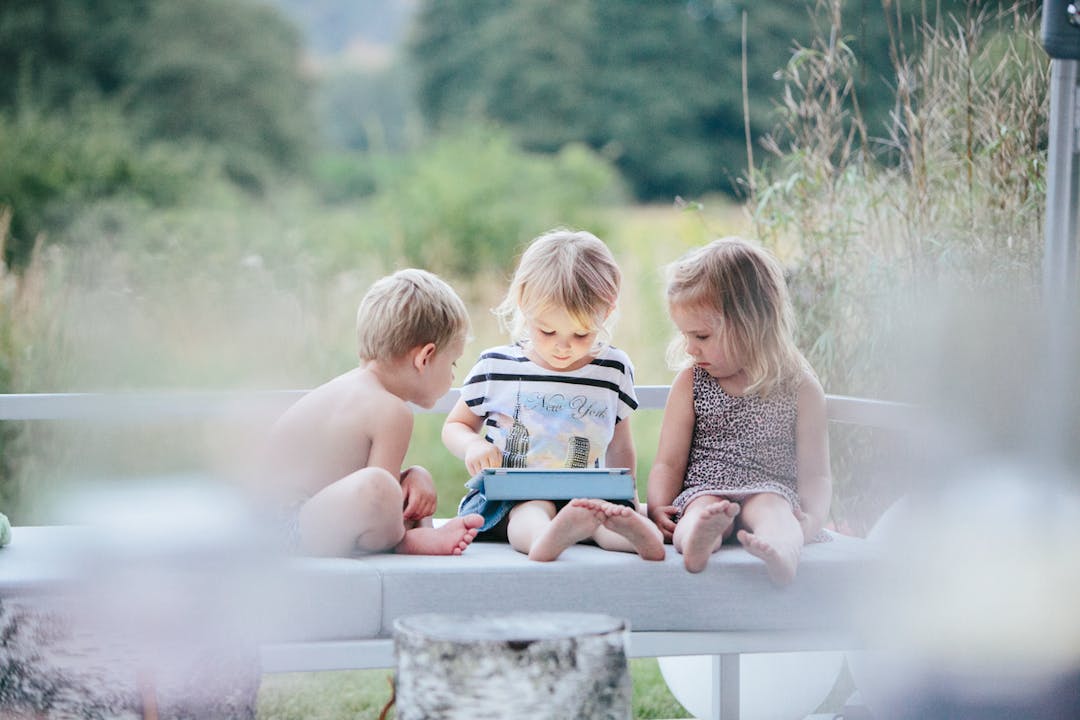 tre barn tittar på ipad