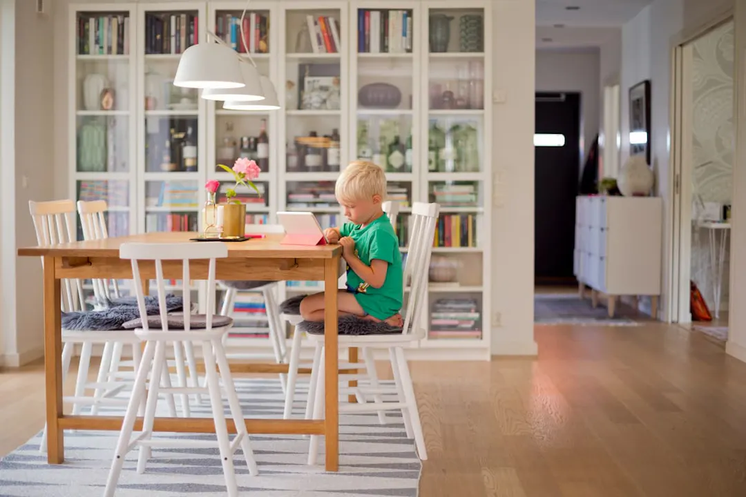 pojke sitter ensam vid köksbord