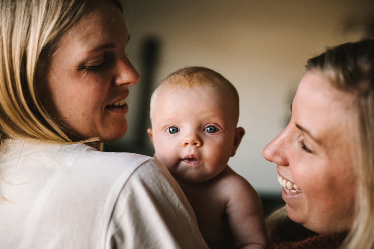 nyfödd bebis med sina mammor