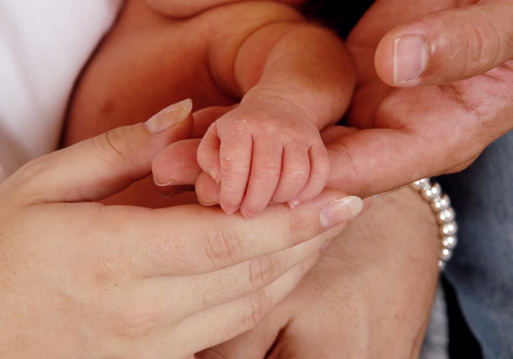 föräldrar som håller hand med bebis