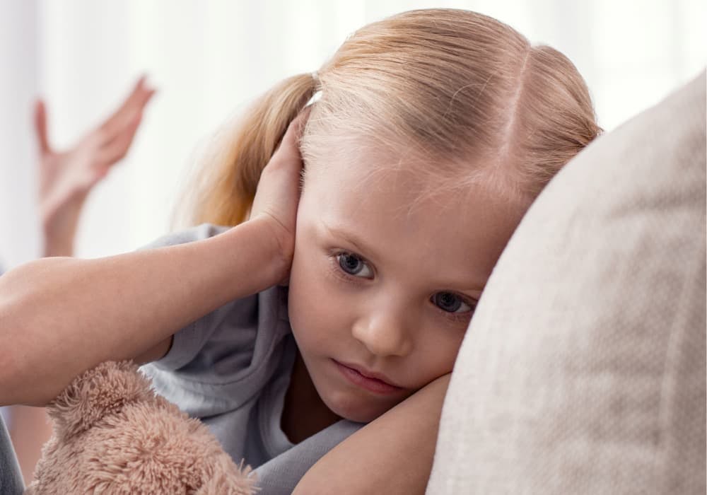 flicka håller för öronen