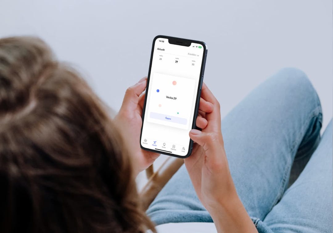 kvinna som håller i telefon som visar Knodd-appen