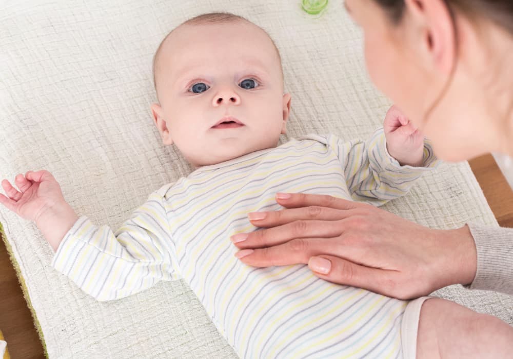 mamma som tar bebis på magen