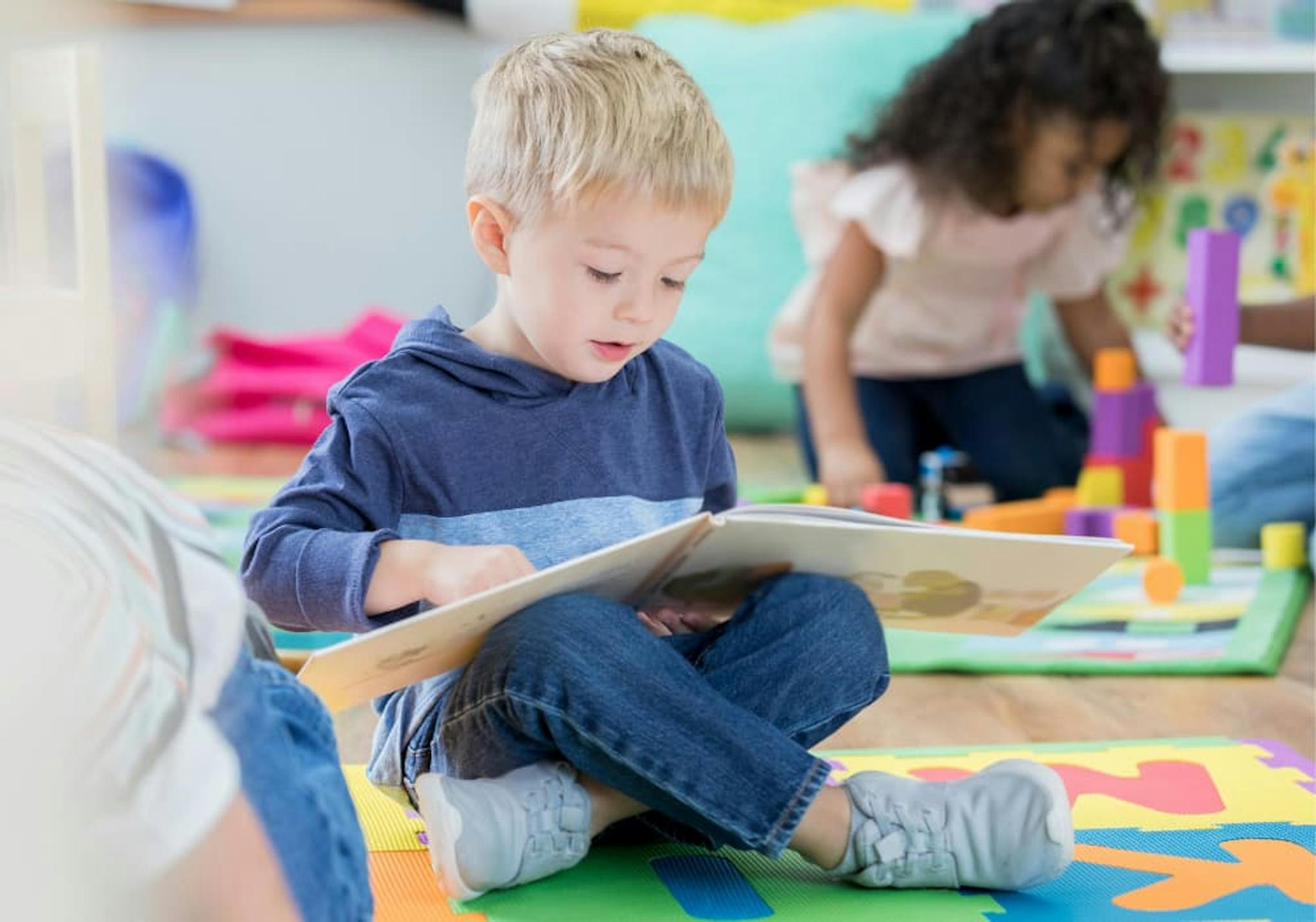 Pojke som läser en bok på förskolan