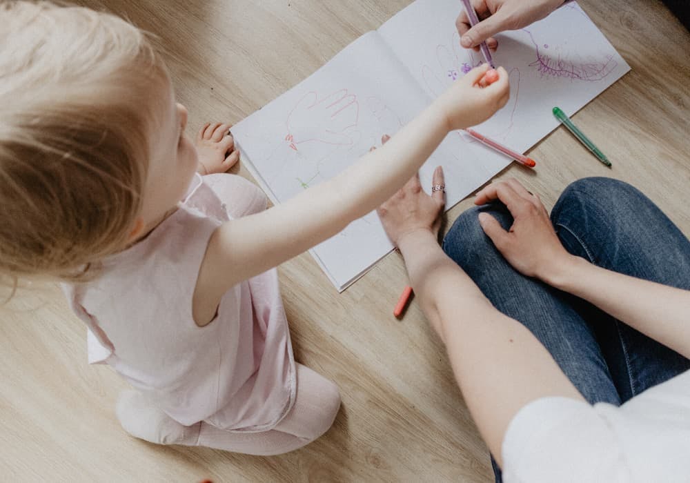 barn som sitter på golvet och ritar