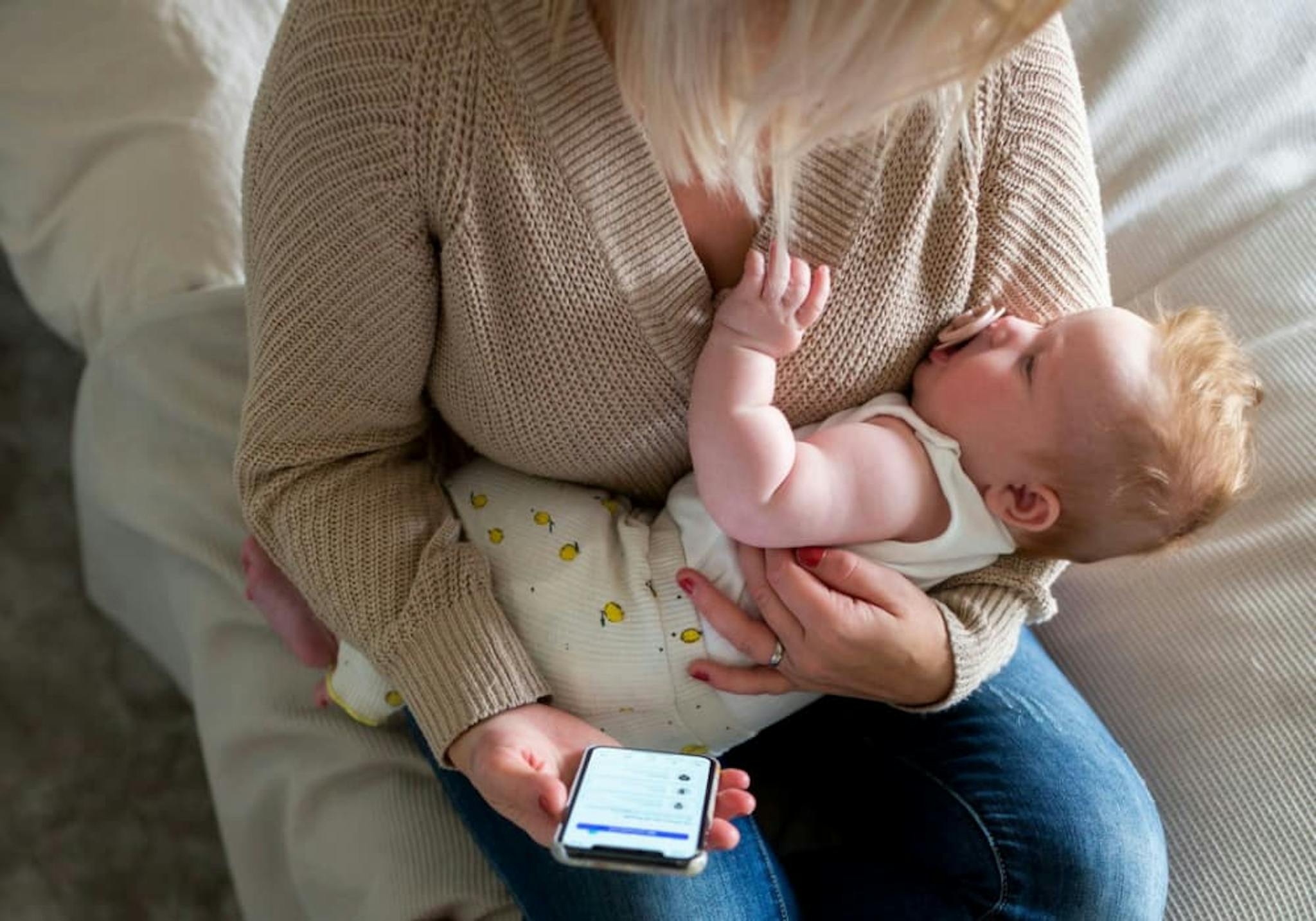 Mamma med bebis i knät