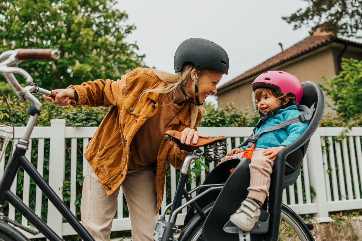 Mamma och barn på cykel med hjälm