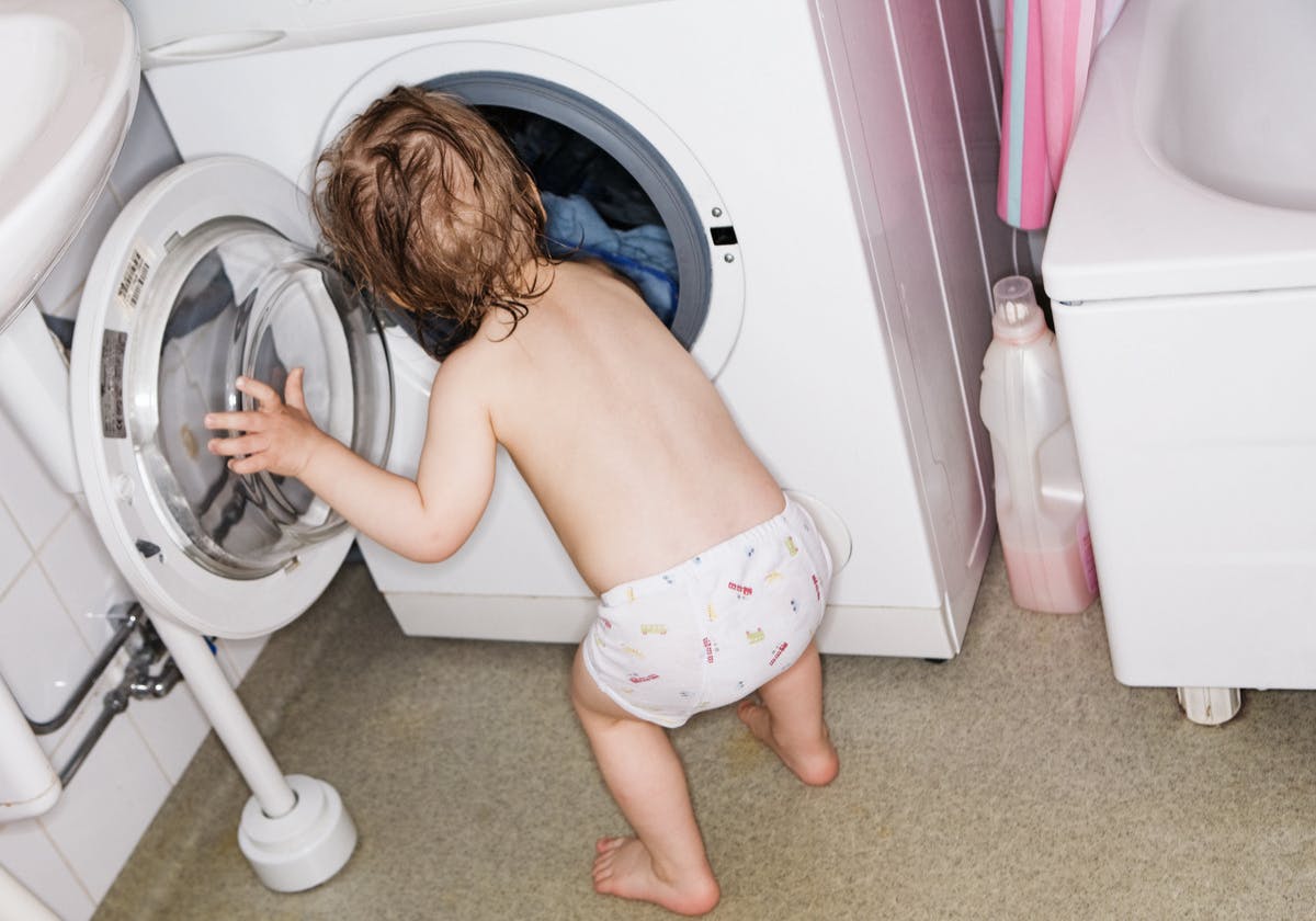 barn framför tvättmaskin