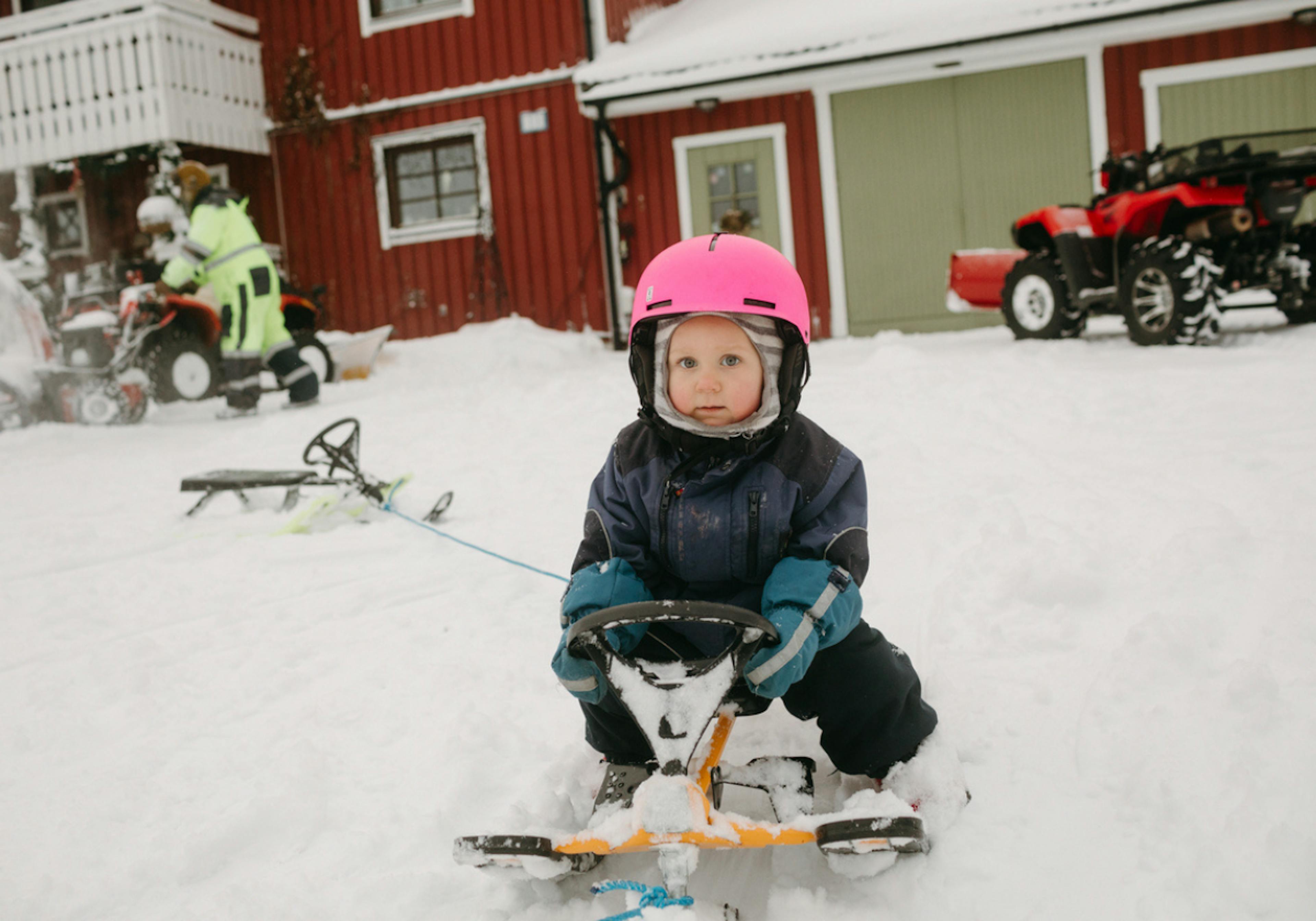 barn åker snowracer med hjälm