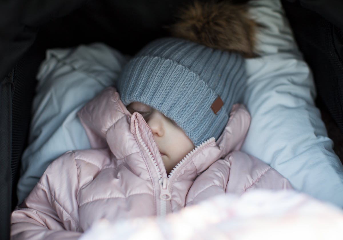 Litet barn sover i vagn ute