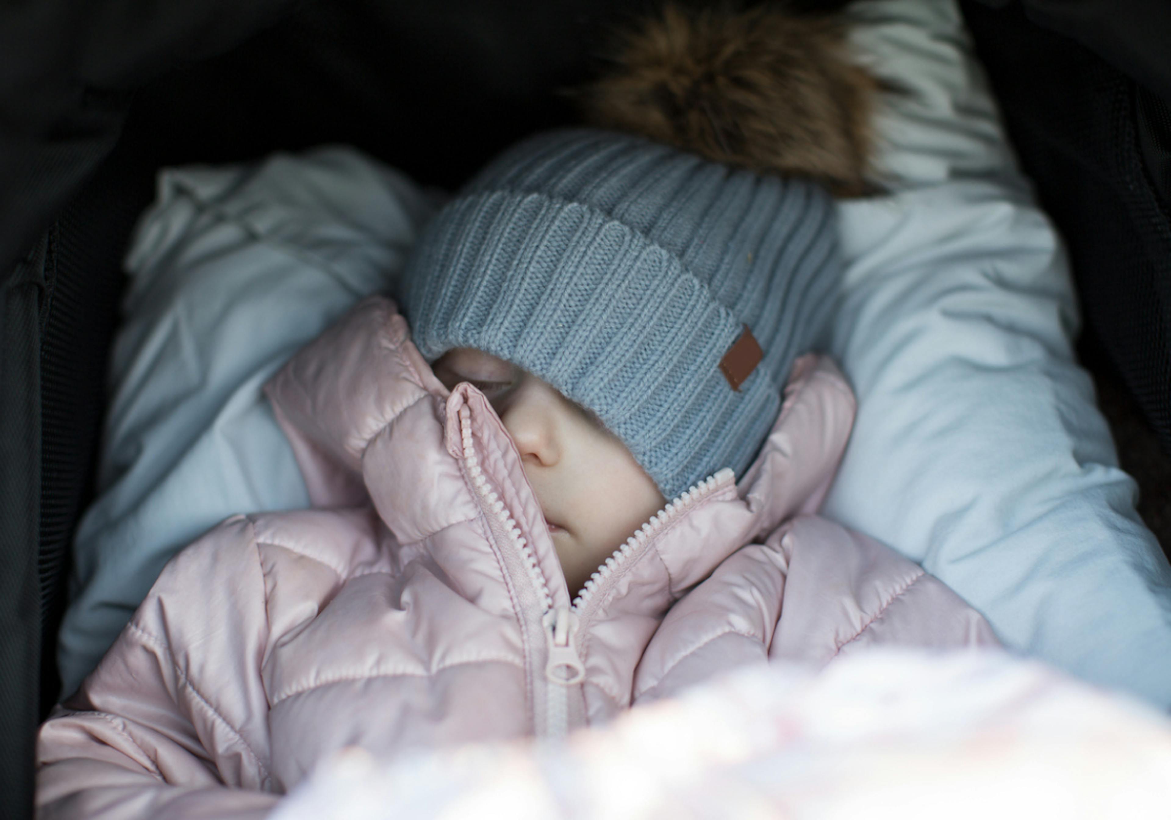 Litet barn sover i vagn ute