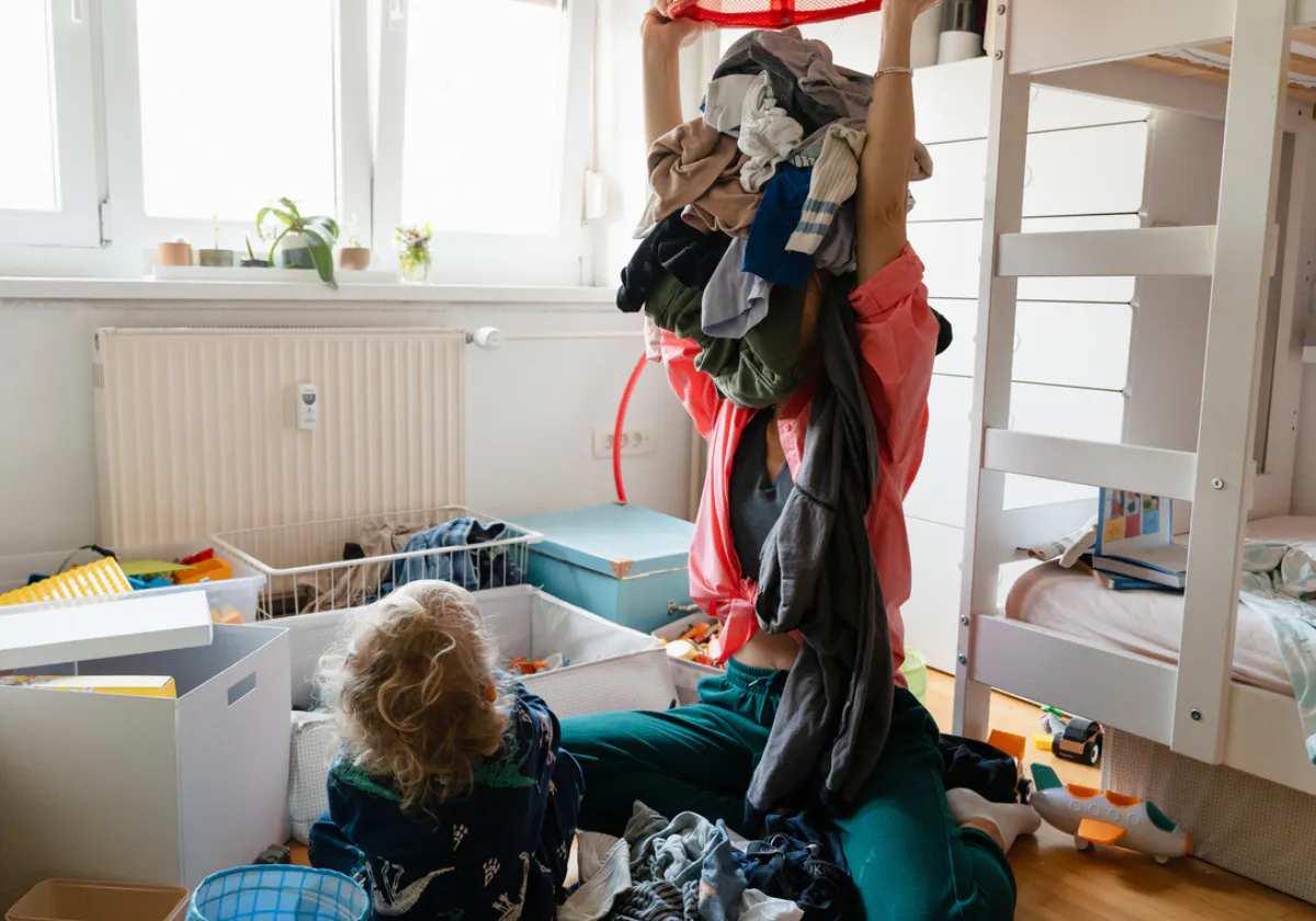 Mamma busar med sitt barn med kläder på huvudet.