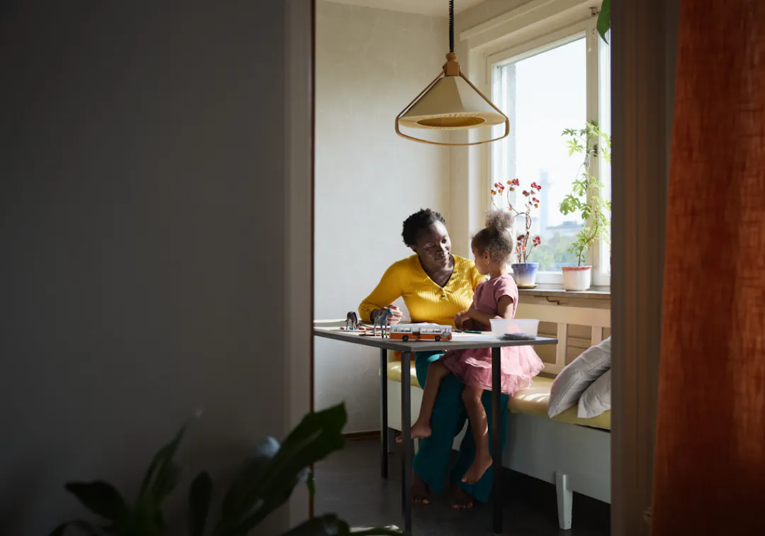 förälder och barn sitter vid köksbordet och leker