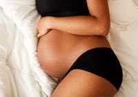 gravid kvinna som ligger på sidan