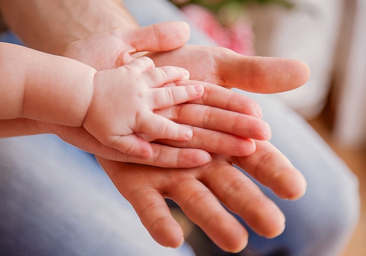 bebis hand och föräldrars händer