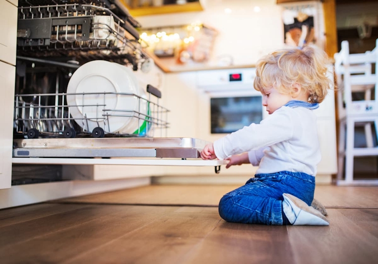 liten pojke vid öppen diskmaskin