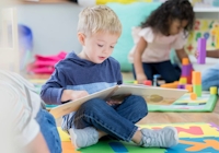 Pojke som läser en bok på förskolan