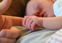 nyfödd bebis håller hand
