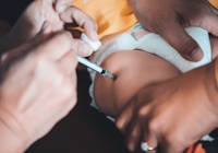 Bebis som får vaccinspruta i låret