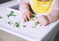 Bebis som äter mosad broccoli