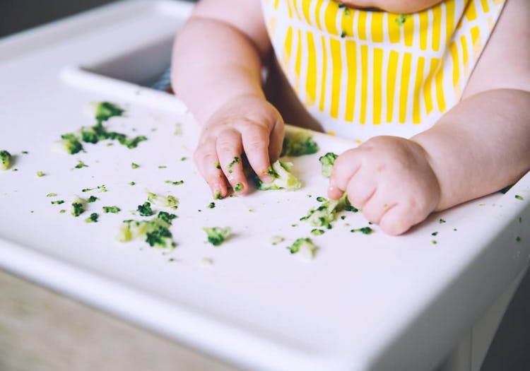 Bebis som äter mosad broccoli