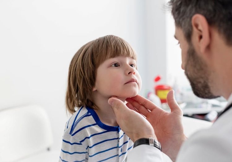 läkare som känner på halen på ett barn