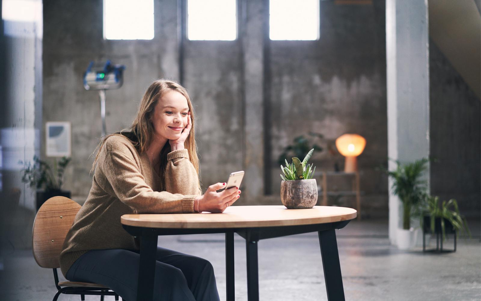 Woman using a smartphone sitting at a table