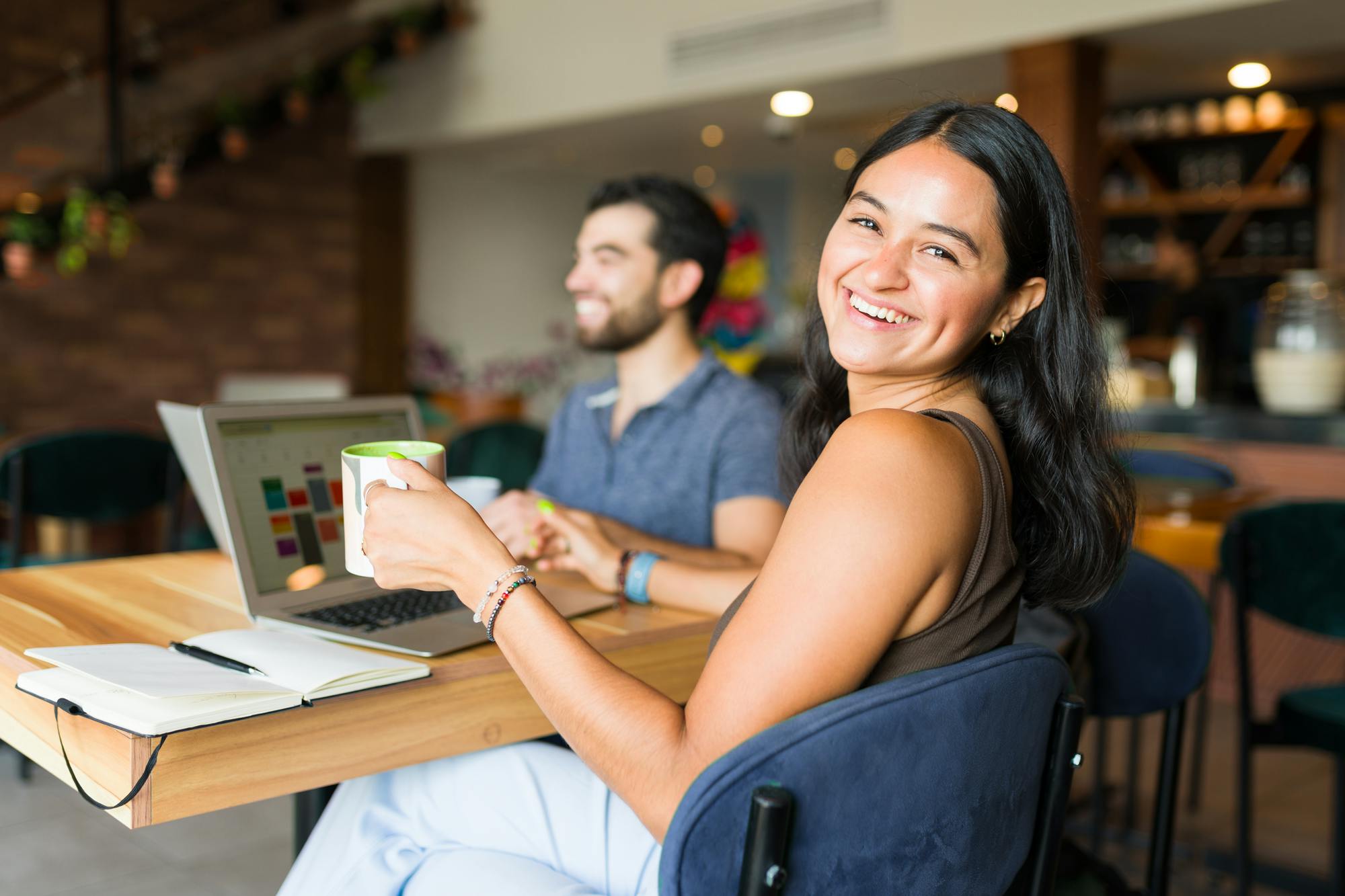ungdomar-pluggar-vid bord på cafe på skolan man ser dator och anteckningar pa bordet