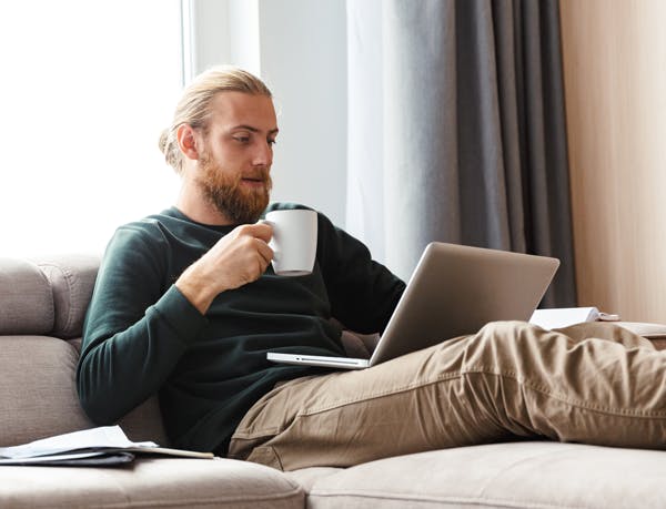 person-i-soffan-kollar-lap-top