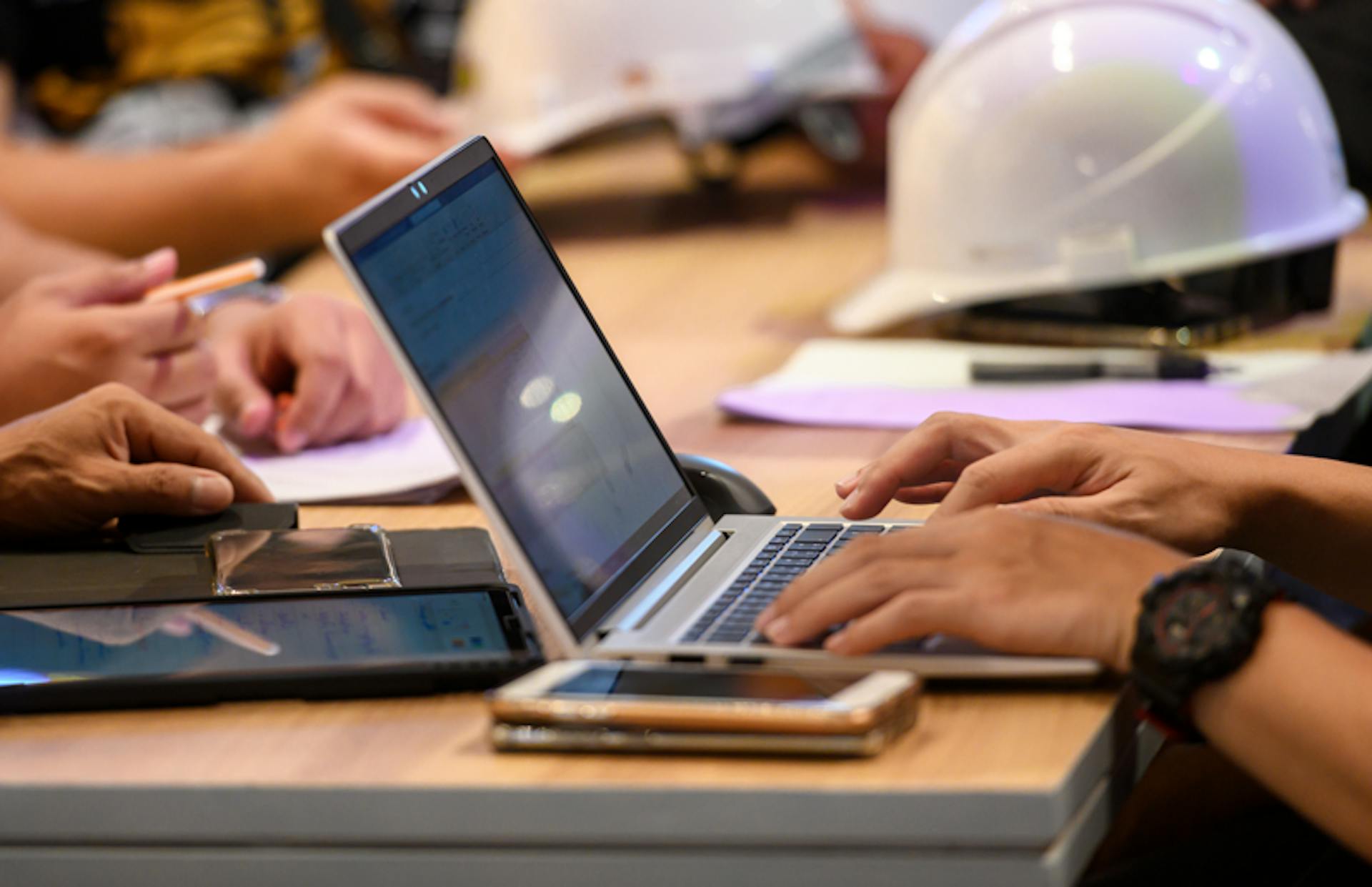 lap-top-pa-bord-ngn-studerar-hjalm-syns-bredvid