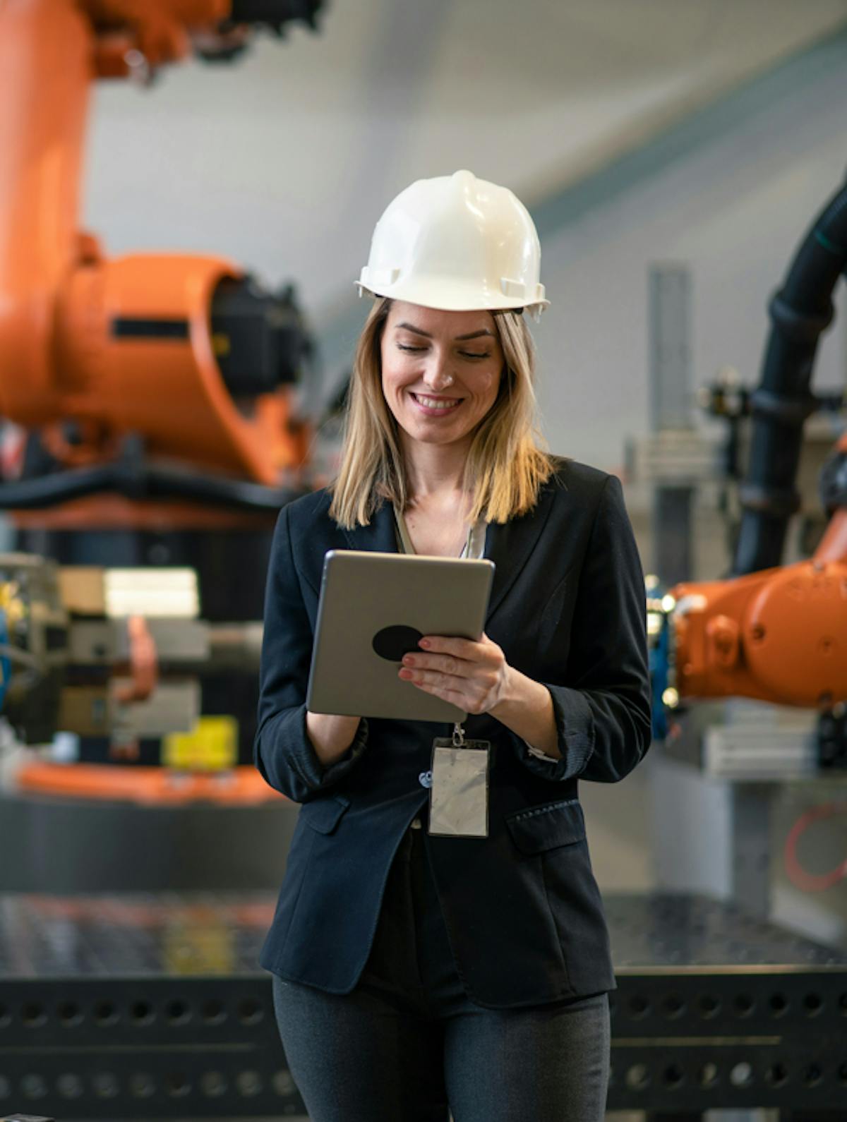 kvinna-med-device-i-hand-robotar-i-bakgrunden