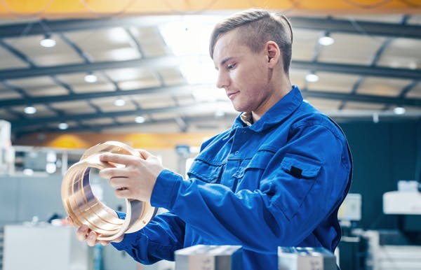 person-med-blaklade-har-metallbit-i-handen