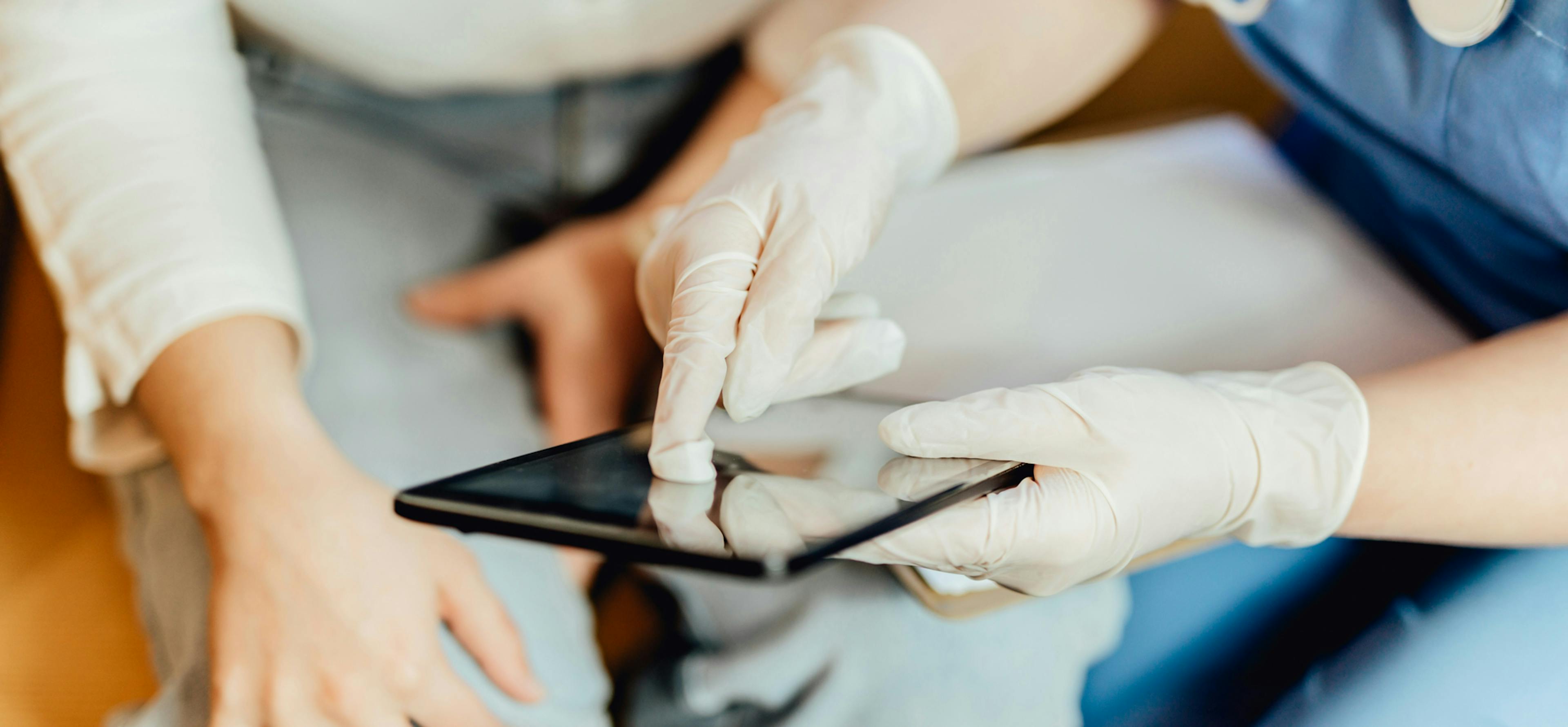 handskkladdperson-haller-device-visar-patient