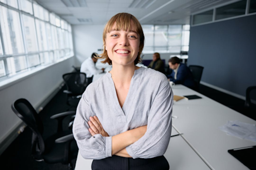 kvinna-i-ljusgra-blus-tittar-i-kameran-och-ler