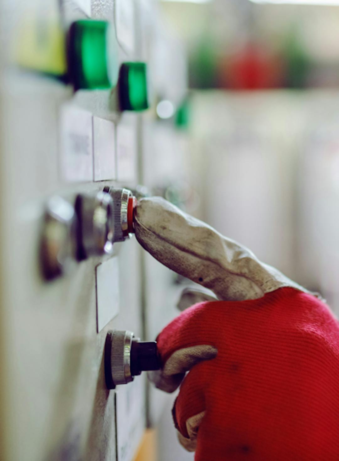 finger-med-handskar-trycker-pa-rod-knapp