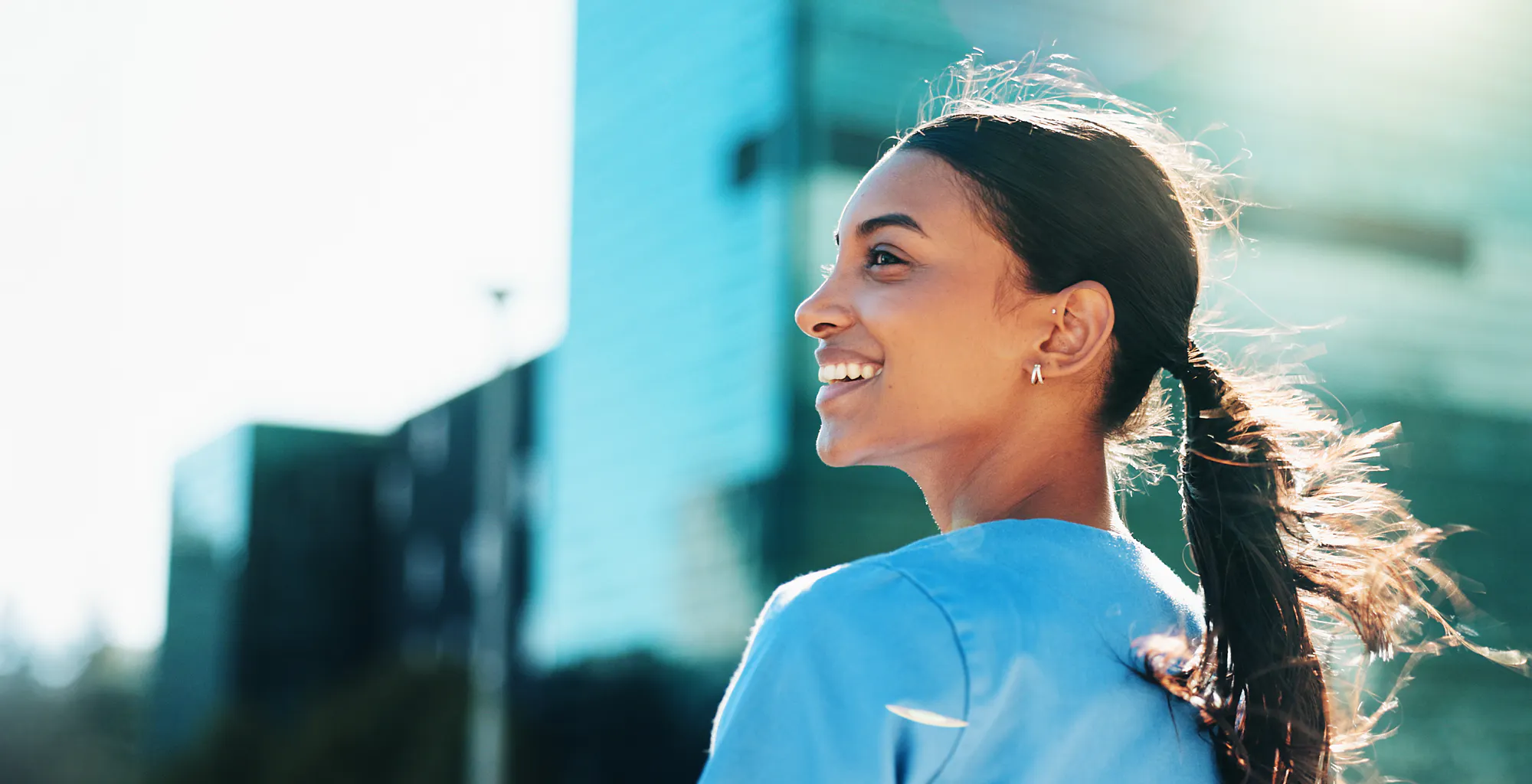 leende-tjej-gar-ute-i-solen-hoghus-i-bakgrunden-3