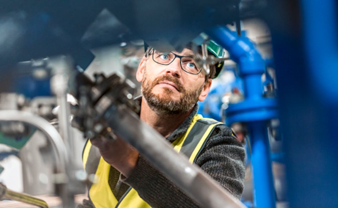 person-inom-industrin-med-hjalm-och-skyddsvast-mdr