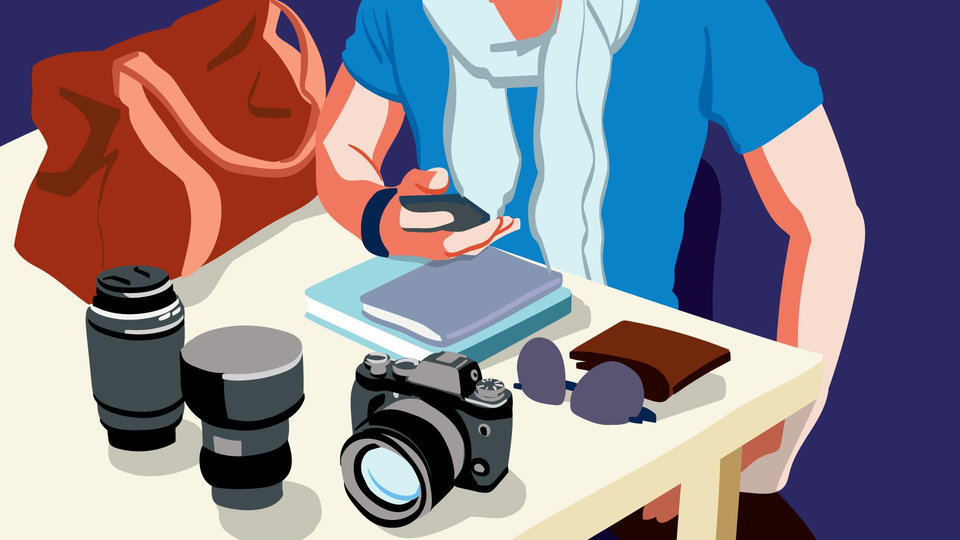 Fotograf vor seiner Kameraausrüstung an einem Tisch sitzend, prüft am Smartphone sinnvolle Tipps und Tricks für erfolgreiches Instagram Marketing. 