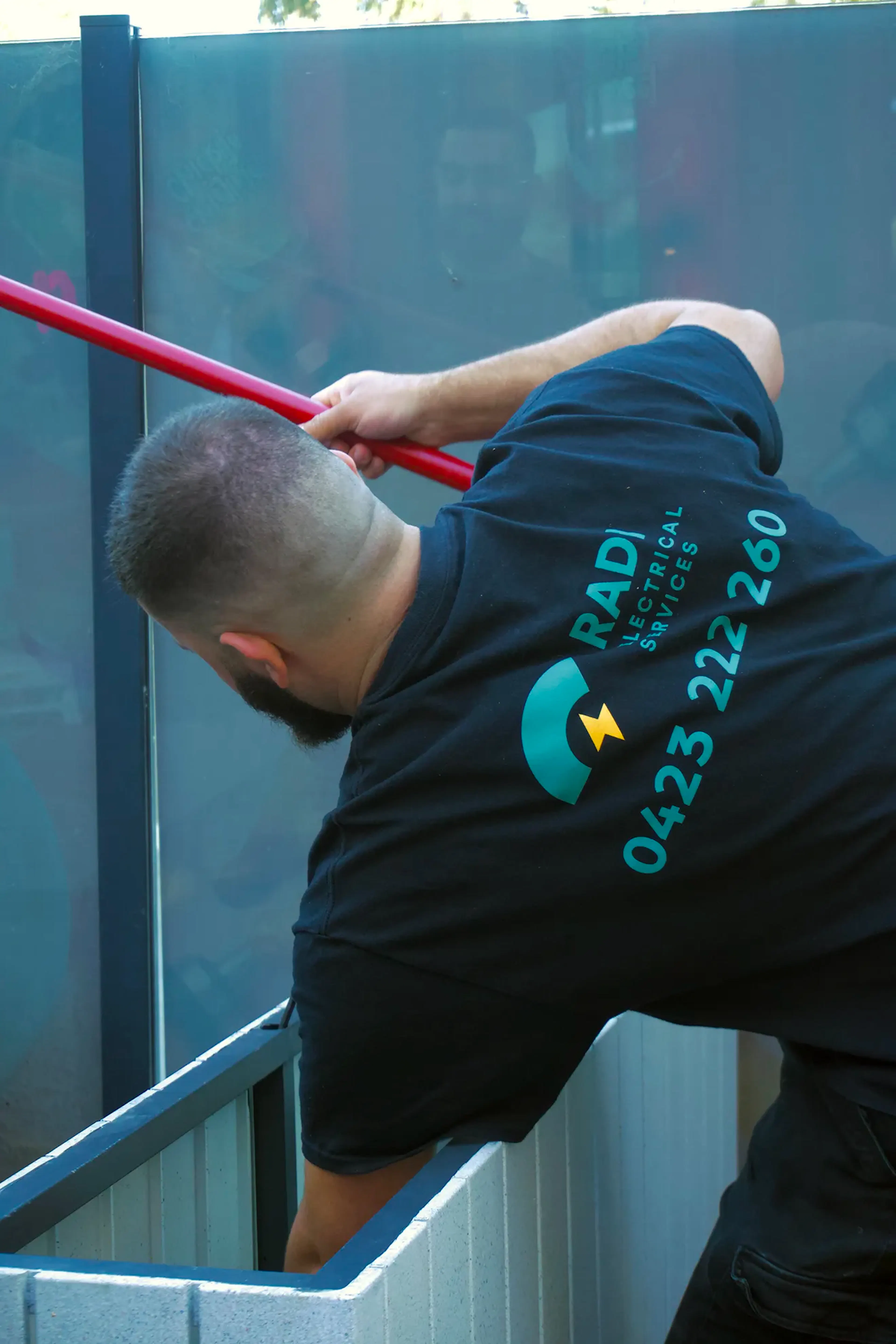 Technician performing detail wiring work on-site with hand tools.