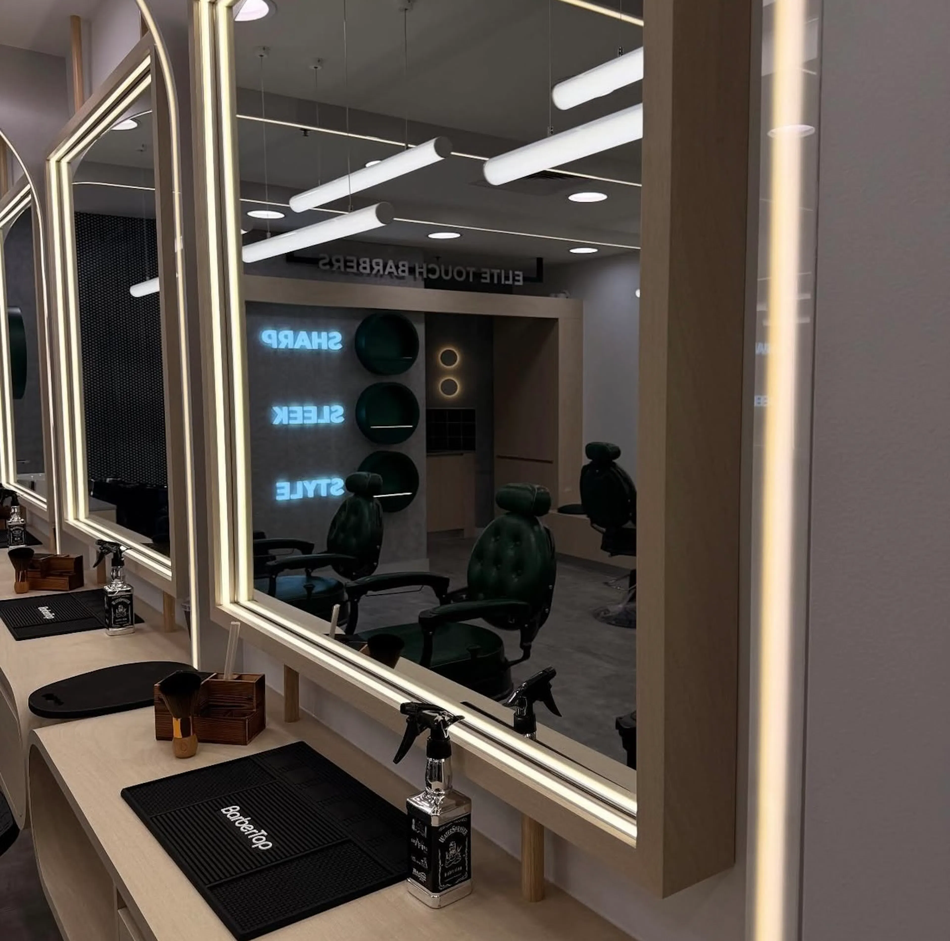 Close-up of a barber mirror framed with glowing double LED strip lighting.