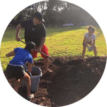 Dad and daughters digging in dirt