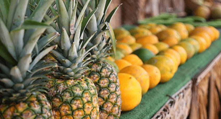 A fruit stand with pineapples and mangos