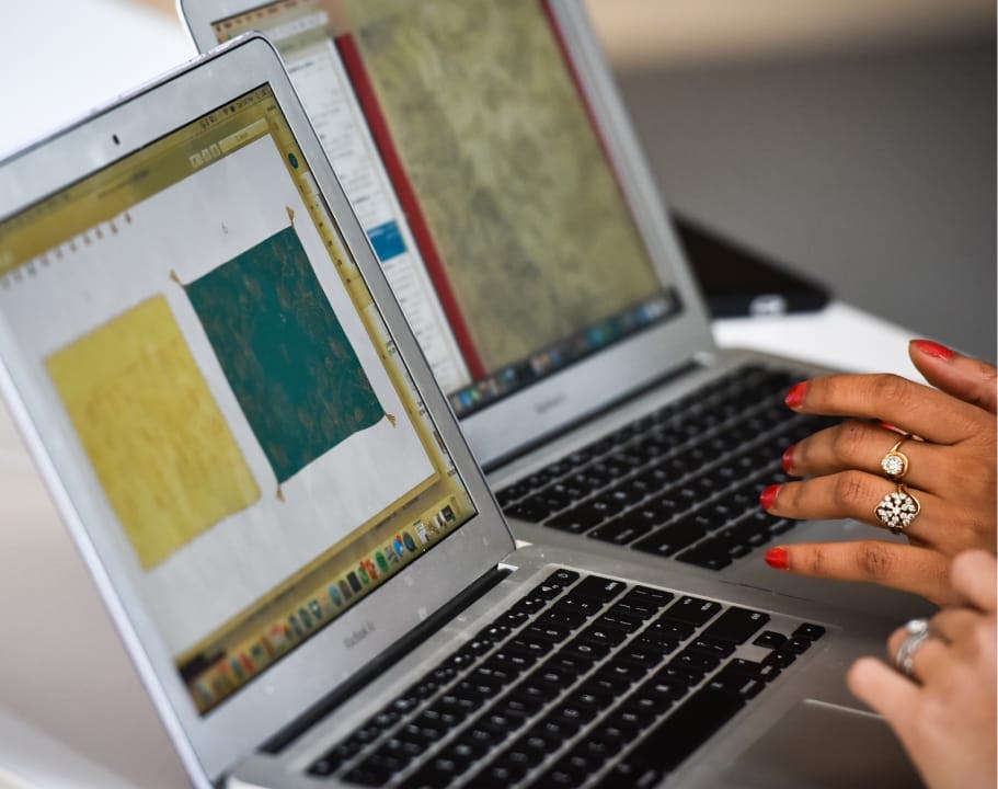 Two people collaborating on fashion designs on their laptops