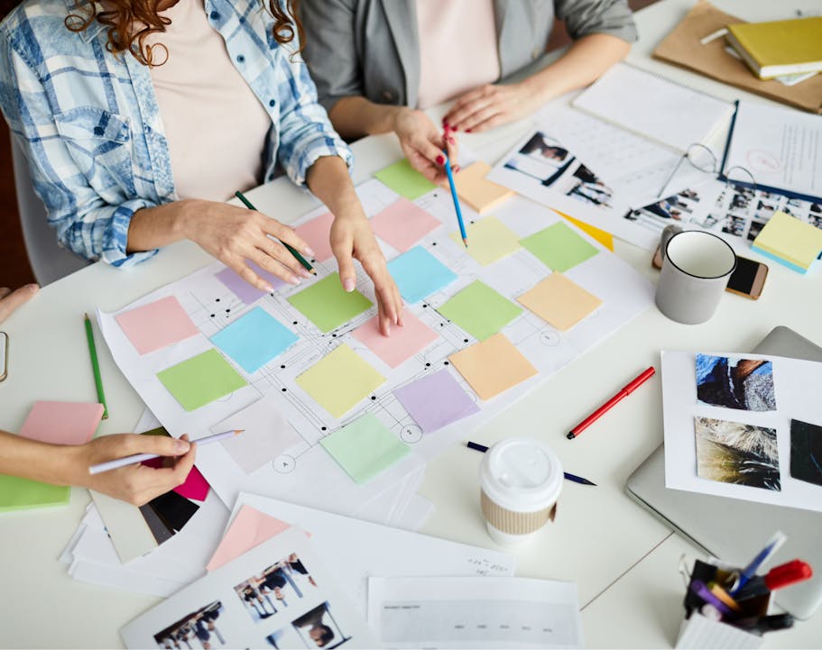 Fashion professionals collaborating at a workstation with post-its and pictures