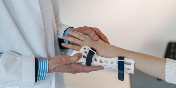 Orthopedic doctor fitting a brace on a patient