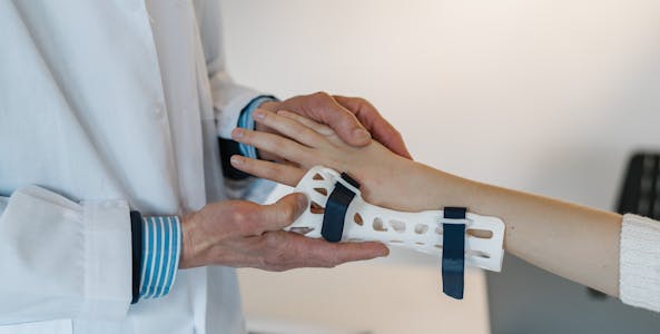 Orthopedic doctor fitting a brace on a patient