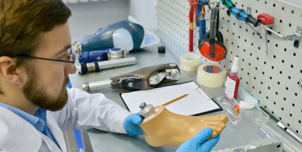 Doctor holding an artificial foot in a lab