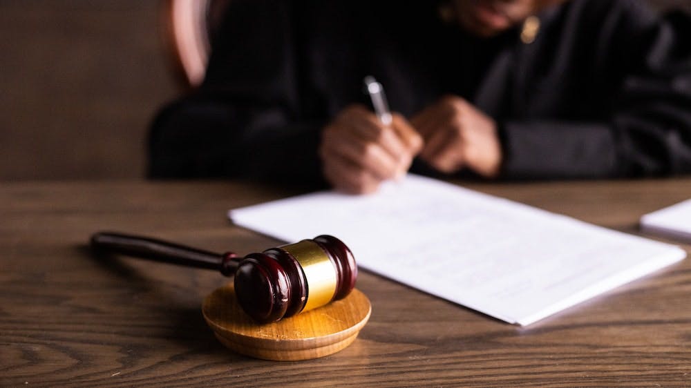 Judge signing legal documents and gavel representing criminal law