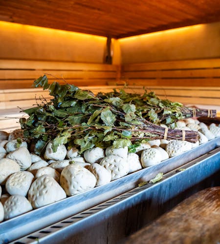 Saunaofen auf dem Birkenreisig liegt