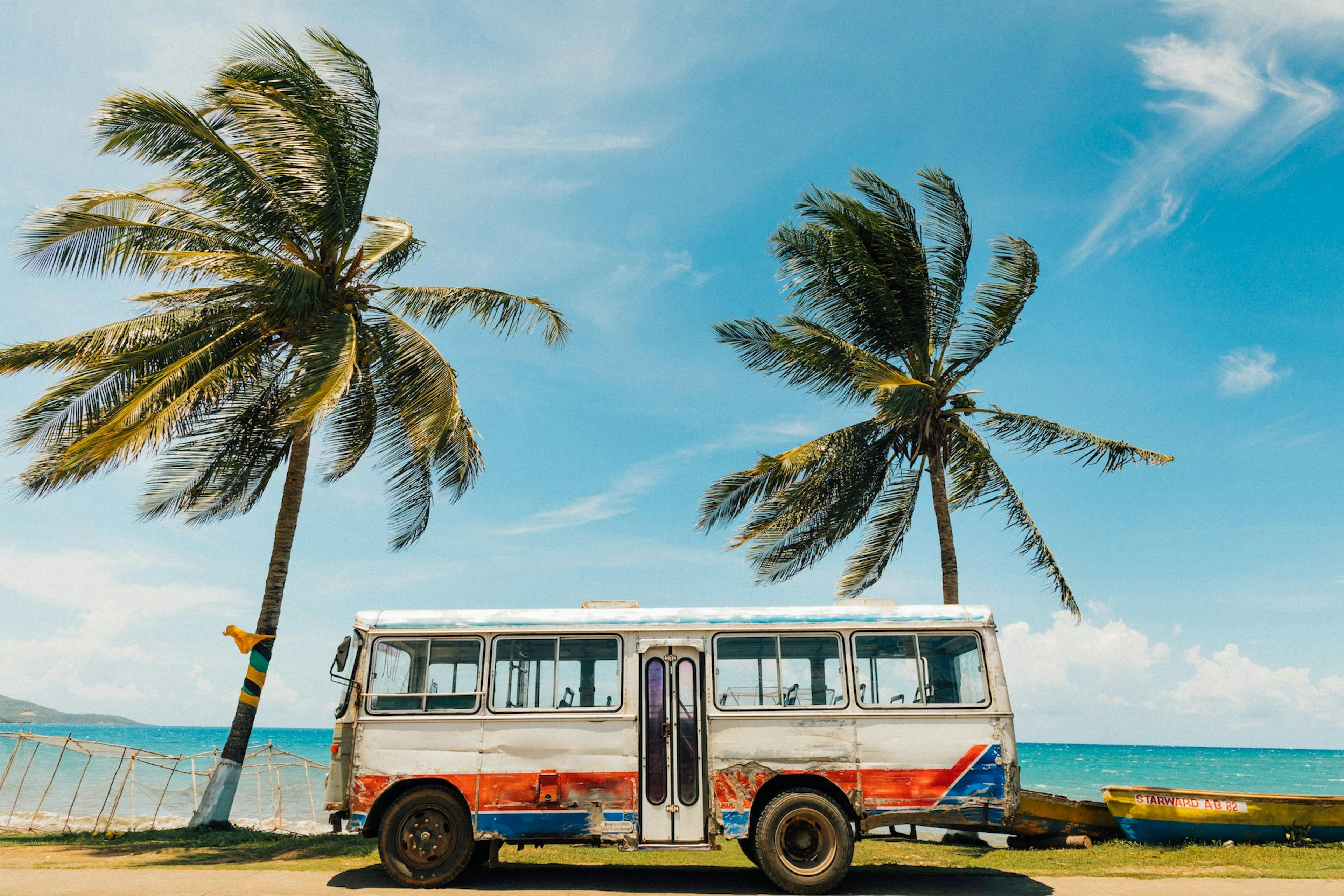 Ein Bus am Strand unter Palmen